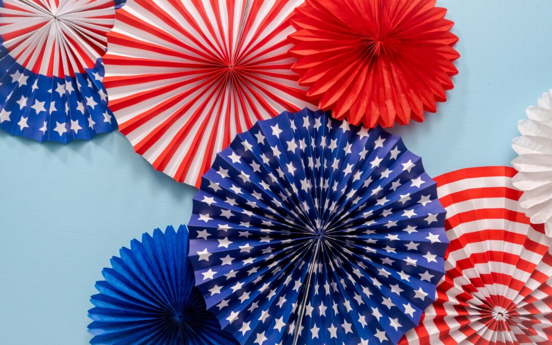 Seven decrorative red, white, and blue paper circles on a light blue background